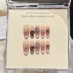 Elegant pink cat-eye press-on nails with rhinestones and black plaid bow design.