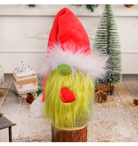 Detail of Christmas gnome plush on wood base with red heart and green beard decor