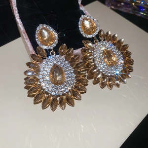Detailed close-up of champagne floral drop earrings with marquise cut crystals in gold