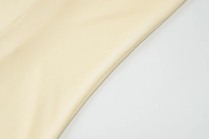 Detaillierte Makroansicht von hellgelbem Webstoff mit feiner Stricktextur für Kleider