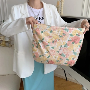 Large capacity floral canvas tote bag shown by model in a minimalist home setting