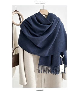 Detail of dark blue cashmere feel scarf featuring soft knit texture and long tassels
