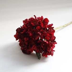 Detail of dark red vintage faux hydrangea with realistic petals and green stem