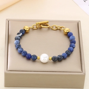 Detail of beaded bracelet with blue stones, white pearl and golden OT toggle clasp