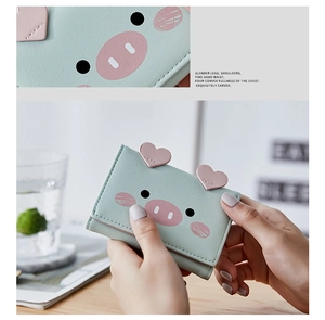 Detail of a green trifold wallet with cute cartoon pig design and premium PU leather texture