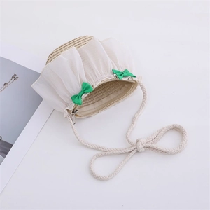 Detail of children's straw crossbody bag with white frills and green bow decorations