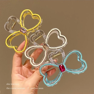 Three rhinestone bow hair claws in yellow, ivory, and blue for elegant women's hairstyles