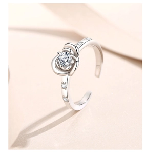 Macro shot of silver rose-shaped ring with zircon center stone and diamond side accents