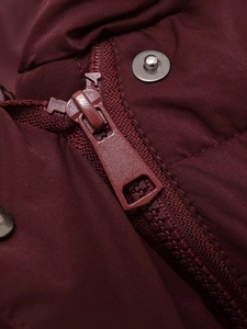 Detail of metal snap buttons and zipper on wine red jacket with high texture quality