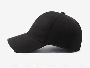 Detail showing brown letter embroidery on the side of a black cotton baseball cap