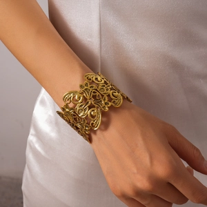 Detailed view of the hollow flower pattern on the vintage golden cuff bracelet