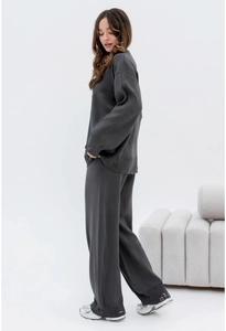 Detail of charcoal grey knit set featuring a relaxed drop-shoulder top and wide-leg trousers