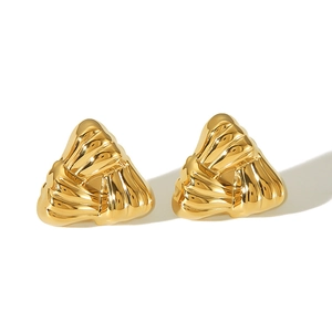Macro detail of golden triangular earrings featuring a textured pleated design finish