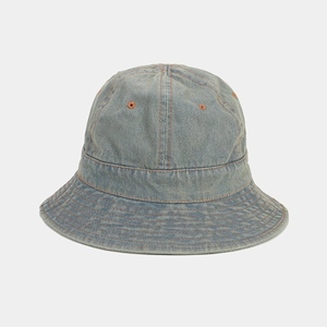 Détail d'un bob en denim bleu clair avec coutures orange contrastées et texture de sergé