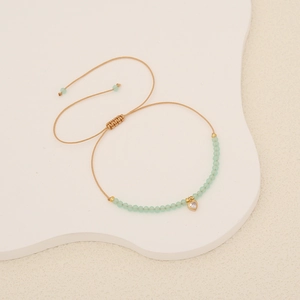 Handmade woven crystal bead bracelet with a gold heart pendant and adjustable cord