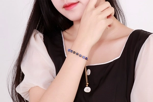 Close-up of a blue natural turquoise bead bracelet with gold accents on woman wrist