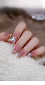 Close-up of 100 mixed Aurora nail crystals on light pink nails with fur background