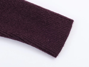 Gros plan détaillé du tissu tricoté violet foncé montrant la texture côtelée verticale