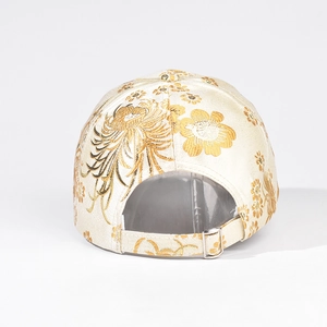 Detail of floral embroidery and adjustable metal buckle on beige baseball cap back