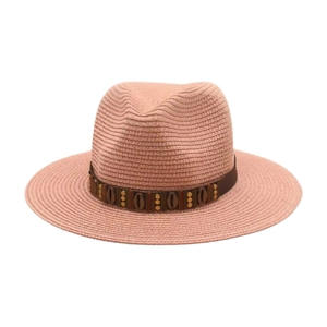 Détail d'un chapeau de paille rose avec ruban perlé et coquillages pour plage et soleil