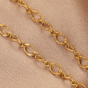 Polished and hammered golden stainless steel geometric oval links on pink silk