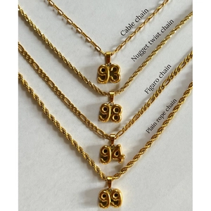 Detail of gold year number pendants on Cable, Figaro, Twist, and Rope chains