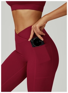 Détail de la taille croisée et de la poche latérale sur le legging de yoga bordeaux