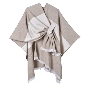 Close-up of khaki and cream color block knit shawl with detailed white fringe hem
