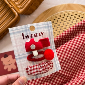 Detail view of handmade red and white fabric bow hair clips and mushroom hair ties