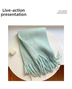 Detail shot of the mint green plush scarf showing soft fluffy texture and long tassels