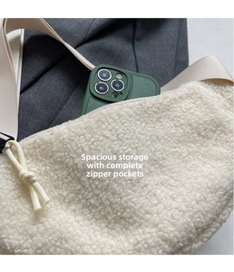 Close-up of white fuzzy shoulder bag showing spacious interior with phone for scale