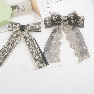 Lace bow accessory with gold floral embroidery on mesh fabric for DIY crafts
