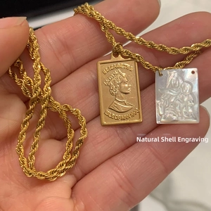 Detail of gold twist chain with Elizabeth II coin and natural shell carving pendants