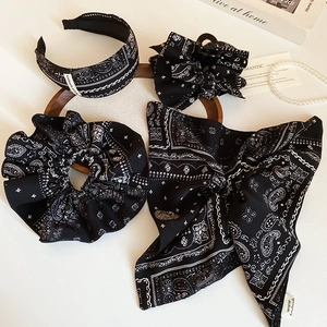 Accessoires cheveux en tissu avec motif cachemire blanc sur fond noir à plat