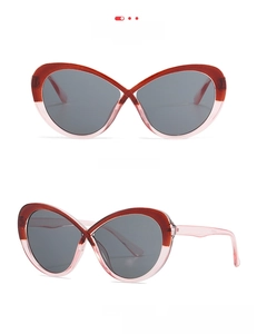 Dettaglio degli occhiali da sole cat-eye bicolore con montatura rosso tè e rosa chiaro