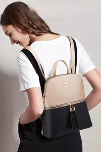 Detail of champagne and black two-tone fashion backpack with tassel zippers