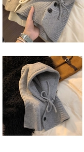 Close-up of light gray knitted balaclava showing chunky wool texture and button details