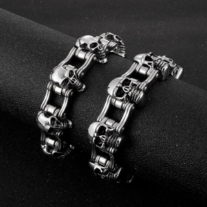 Detail of vintage silver punk skull motorcycle chain bracelet on a black display