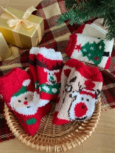 Cozy Christmas coral fleece socks set with Santa and reindeer motifs in a gift basket