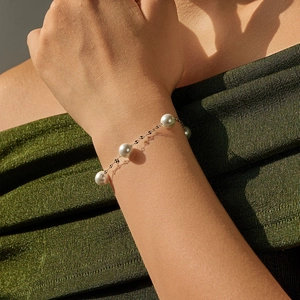 Elegant S925 sterling silver bracelet with white pearls shown on a woman wrist