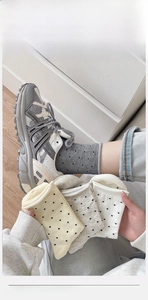 Detailed view of polka dot cotton socks with curled edges and breathable knit texture