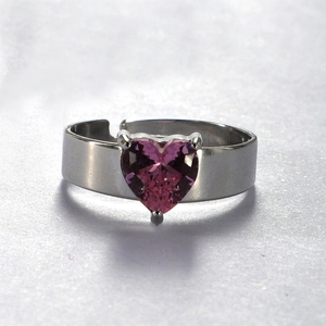 Detailed macro of stainless steel heart ring with pink zircon and open adjustable band
