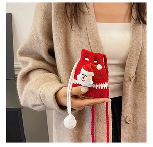 Detail of red crochet Christmas bag with Santa applique and white pompom drawstring