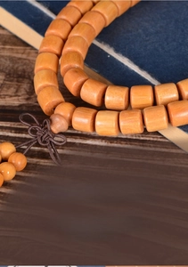 Macro detail of amber sandalwood barrel beads with natural wood grain and woven knot
