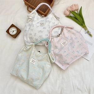 Detail showing cat print canvas tote bags with colorful polka dot rope handles and snap