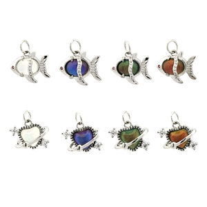 Macro view of 18K gold-plated fish and heart pendants with color-changing mood stones