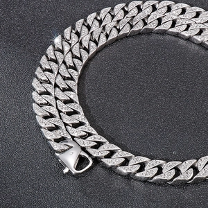 Close-up of a silver Cuban link chain with sparkling pavé stones and a secure lobster clasp