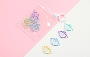 Detail of colorful Saturn-shaped metal paper clips with clear zipper storage pouch