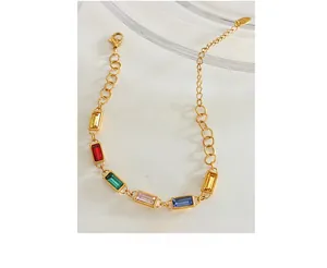 Close-up of gold chain bracelet with colorful rectangular zircon gemstones and lobster clasp