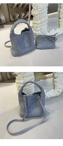 Detail of greyish-blue woven denim tote bag and matching clutch set with silver hardware